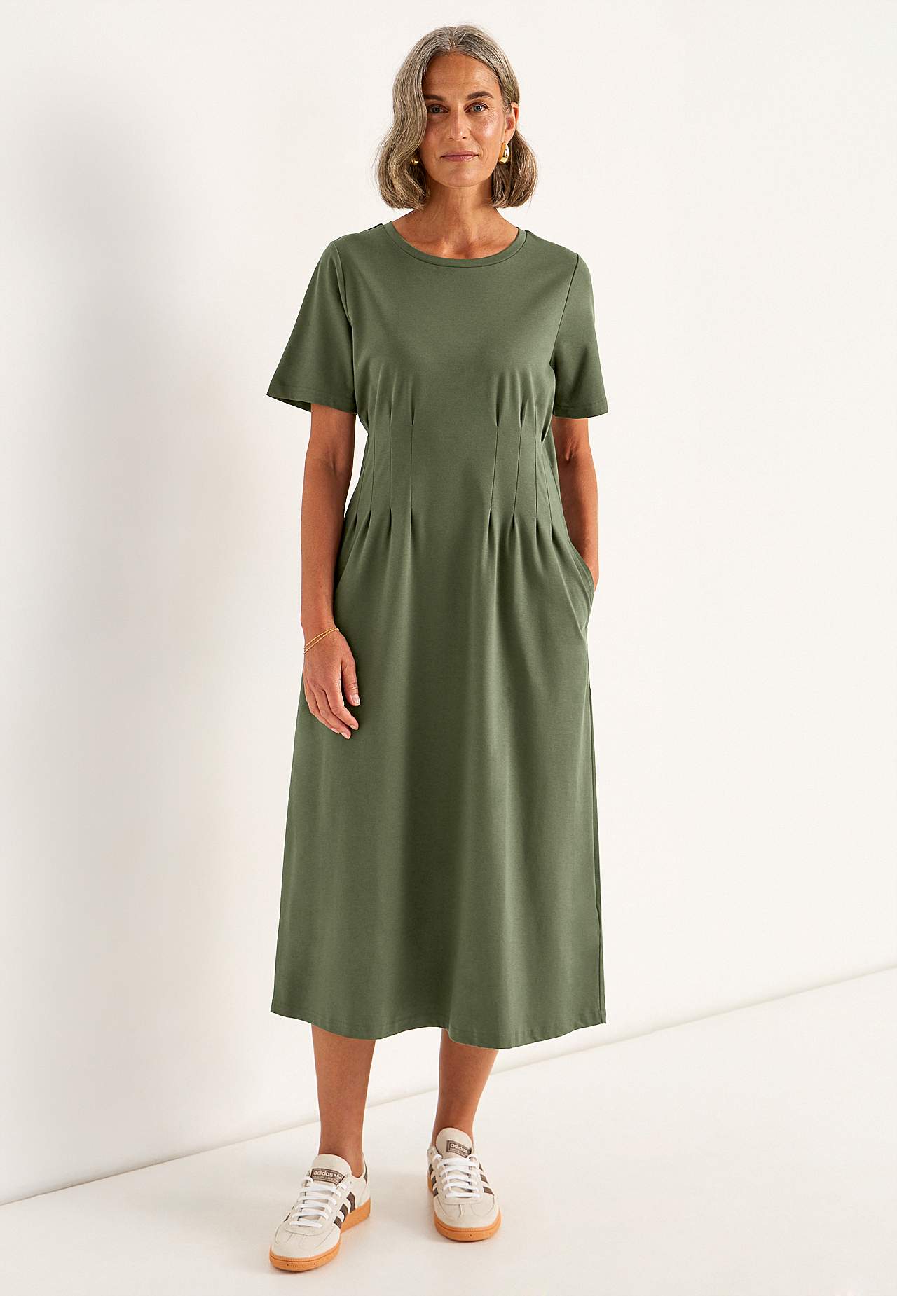 Woman wearing a jersey midi dress with sneakers